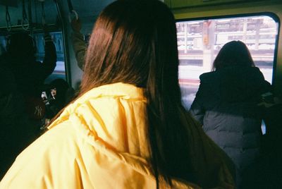 Rear view of woman sitting in bus