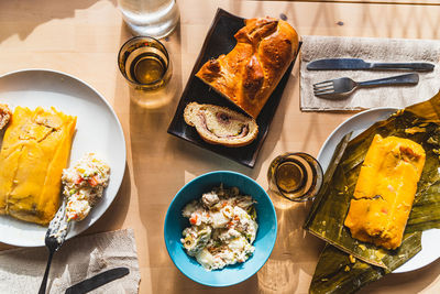 Venezuelan christmas food display on table with traditional hallacas, pan de jamon 
