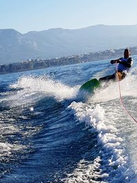 Man surfing in sea against clear sky