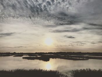 Scenic view of lake against sky at sunset