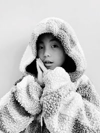 Portrait of young woman standing against white background