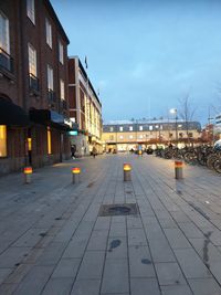 Street amidst buildings against sky at dusk