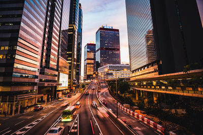 Traffic on road amidst buildings in city against sky