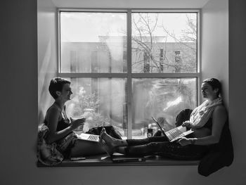 Young couple sitting on window