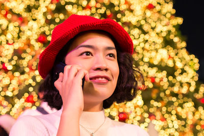 Portrait of smiling young woman with christmas tree