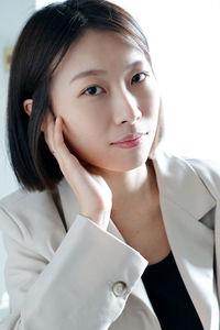 Portrait of young woman against white background