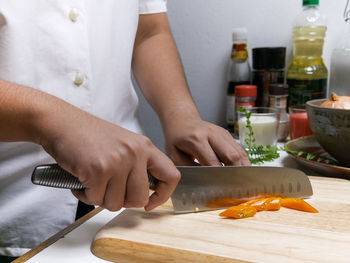 Midsection of woman preparing food on cutting board