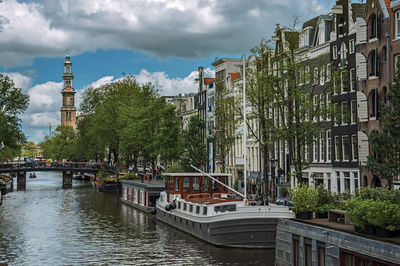 Tree-lined canal with old buildings and boats in amsterdam. the netherland capital full of canals.