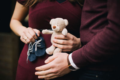 Midsection of couple with teddy bead and shoe