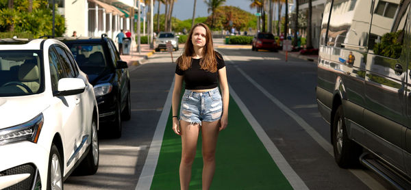 Portrait of young woman standing in city