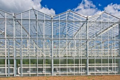 Metallic structure in greenhouse against sky