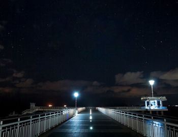 Illuminated bridge against sky at night