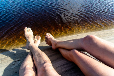 Low section of woman relaxing at beach