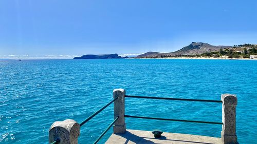 Scenic view of bay against clear blue sky