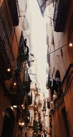 Low angle view of illuminated street amidst buildings in city