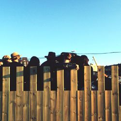 Low angle view of people against clear blue sky