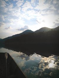 Scenic view of lake by mountains against sky