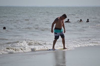 Man surfboarding at seashore