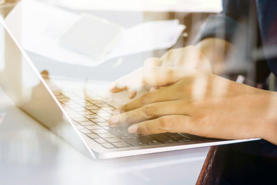 Midsection of man using laptop on table