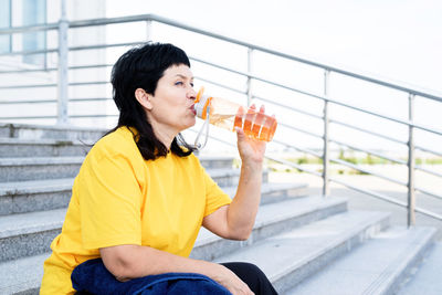 Side view of mid adult man looking away while sitting outdoors