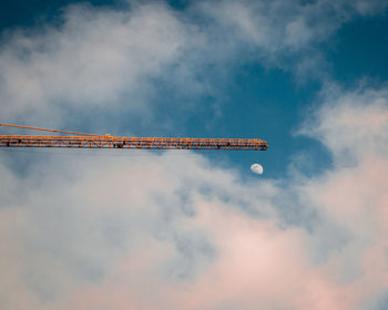 Low angle view of crane against sky