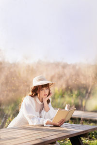 Young woman using laptop while sitting on table