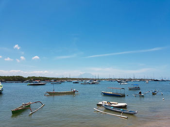 Boats moored in sea against sky