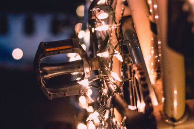 Close-up of illuminated string lights on bicycle at night