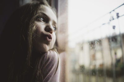 Portrait of woman looking through window