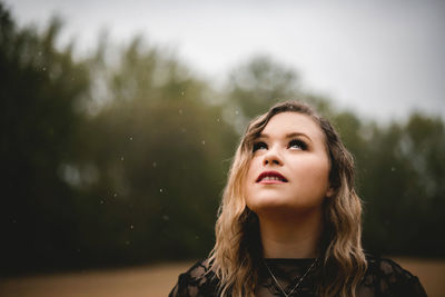 Portrait of a beautiful young woman in rain