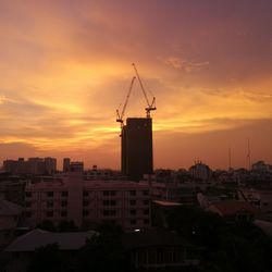 Silhouette cityscape against sky during sunset