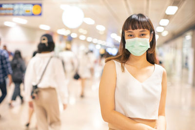 Portrait of woman standing against illuminated lighting equipment