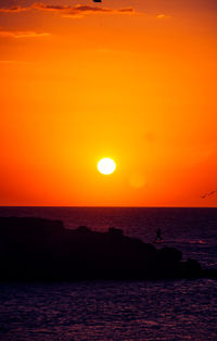 Scenic view of sea against romantic sky at sunset