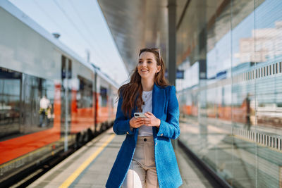 Portrait of young woman standing in city