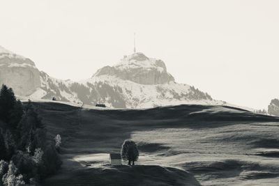 People on snowcapped mountain against clear sky