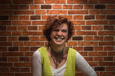 Portrait of woman against brick wall