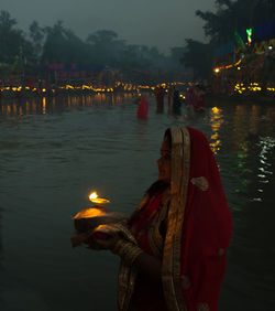 Reflection of people on water at night