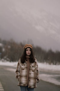 Portrait of young woman standing in snow