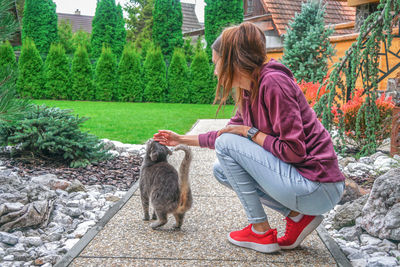 A young woman strokes a cat.
