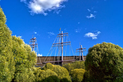Low angle view of trees and masts at vasa museum against sky
