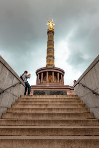 Low angle view of man standing on staircase of building