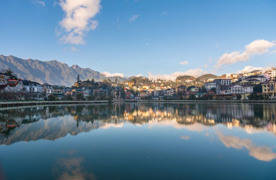 Reflection of buildings in city against sky