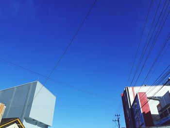 Low angle view of cables against clear blue sky