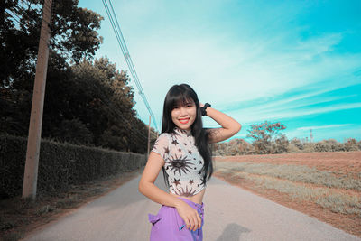 Portrait of a smiling girl standing on road