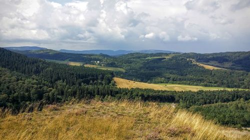 Scenic view of field against cloudy sky