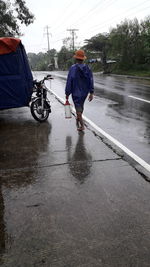 Man with umbrella on wet road