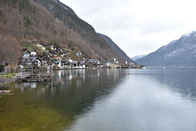 Scenic view of lake by buildings against sky