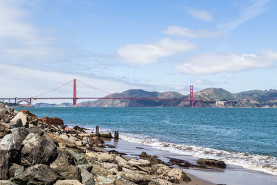 Suspension bridge over sea against sky