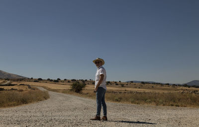 Adult man in cowboy hat on dirt road against sky. castilla y leon, spain