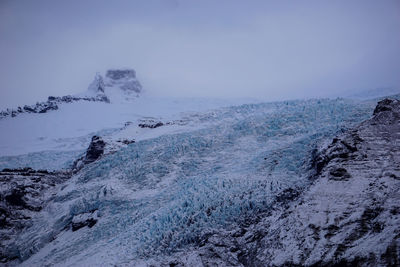 Scenic view of snowcapped mountains by sea against sky